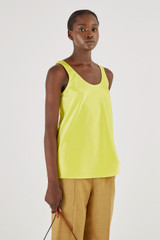 Profile view of model wearing the Oroton Fluid Satin Tank in Citrine and 80% Acetate, 20% Polyester for Women