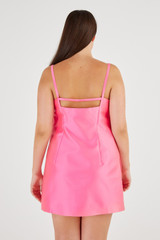 Profile view of model wearing the Oroton Satin Mini Bow Dress in Candy Pink and 85% Polyester, 15% Silk for Women