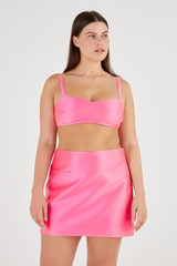 Profile view of model wearing the Oroton Satin Mini Skirt in Candy Pink and 85% Polyester, 15% Silk for Women