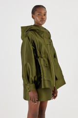 Profile view of model wearing the Oroton Satin Parka in Khaki and 85% Polyester, 15% Silk for Women