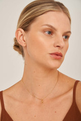 Profile view of model wearing the Oroton Petite Luna Letter Necklace in Gold and  for Women
