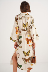 Profile view of model wearing the Oroton Butterfly Print Dress in Vanilla Bean and 100% Silk for Women