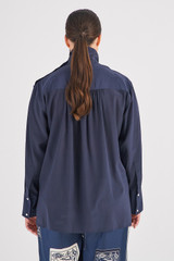 Profile view of model wearing the Oroton High Neck Silk Blouse in North Sea and 100% Silk for Women