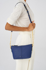 Profile view of model wearing the Oroton Lilly Zip Top Crossbody in Azure Blue and Pebble Leather for Women