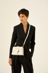 Profile view of model wearing the Oroton Frida Mini Satchel in Clotted Cream and Smooth Leather for Women