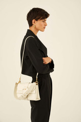 Profile view of model wearing the Oroton Frida Mini Satchel in Clotted Cream and Smooth Leather for Women