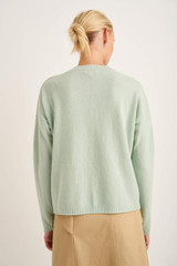 Profile view of model wearing the Oroton V-Neck Knit in Pale Topaz and 100% Wool for Women