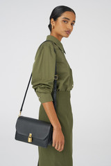 Profile view of model wearing the Oroton Tate Medium Day Bag in Black and Pebble Leather for Women