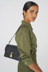 Profile view of model wearing the Oroton Tate Medium Day Bag in Black and Pebble Leather for Women