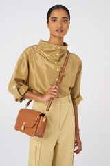 Profile view of model wearing the Oroton Tate Medium Day Bag in Brandy and Pebble Leather for Women