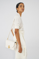 Profile view of model wearing the Oroton Tate Medium Day Bag in Paper White and Pebble Leather for Women