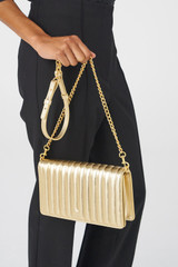 Profile view of model wearing the Oroton Fay Medium Chain Crossbody in Gold and Metallic Pebble Leather for Women