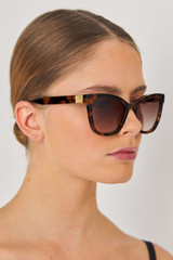 Profile view of model wearing the Oroton Frankie Sunglasses in Signature Tort and Acetate for Women