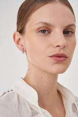 Profile view of model wearing the Oroton Wrenley Drop Studs in Silver and Brass Base Metal With Rhodium Plating for Women