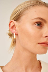 Profile view of model wearing the Oroton Elin Sleepers in Gold and Brass Base With 18CT Gold Plating for Women
