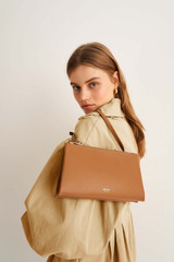 Profile view of model wearing the Oroton Wilde Double Zip Crossbody in Dark Rye and Smooth Leather for Women