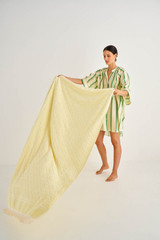 Profile view of model wearing the Oroton Sebastian Beach Towel in Lemon Ice and Cotton Terry Towelling for Women