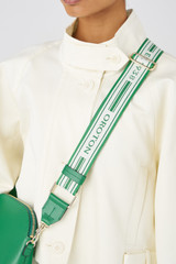 Profile view of model wearing the Oroton Heather Long Webbing Strap in Emerald/Cream and Polyester webbing strap and pebble leather trim for Women