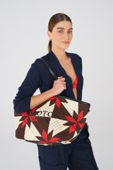 Profile view of model wearing the Oroton Boyd Quilted Tote in Dark Poppy Mix and 100% cotton twill canvas for 