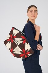 Profile view of model wearing the Oroton Boyd Quilted Tote in Dark Poppy Mix and 100% cotton twill canvas for Women