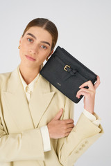 Profile view of model wearing the Oroton Margot Crossbody in Black and Pebble leather for Women