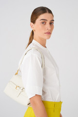 Profile view of model wearing the Oroton Margot Small Top Handle in Clotted Cream and Pebble leather for Women