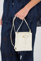 Profile view of model wearing the Oroton Margot Tiny Bucket Bag in Clotted Cream and Pebble leather for Women