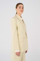 Profile view of model wearing the Oroton Blazer in Almond and 58% Viscose, 42% Cotton for Women