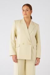 Profile view of model wearing the Oroton Blazer in Almond and 58% Viscose, 42% Cotton for Women