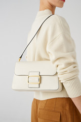 Profile view of model wearing the Oroton Astrid Shoulder Bag in Cream and Pebble leather for Women