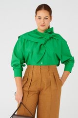 Profile view of model wearing the Oroton Cape Blouse in Jewel Green and 100% cotton for Women