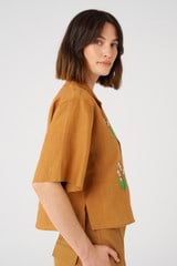 Profile view of model wearing the Oroton Lily Embroidered Shirt in Tan and 100% linen for Women