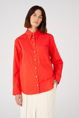 Profile view of model wearing the Oroton Poplin Long Sleeve Shirt in Poppy and 100% cotton for Women