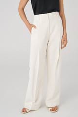 Profile view of model wearing the Oroton Pleat Slouch Pant in Cream and 58% viscose, 42% linen for Women