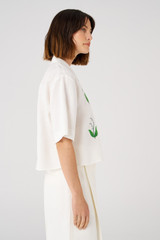 Profile view of model wearing the Oroton Lily Embroidered Shirt in White and 100% linen for Women