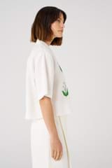 Profile view of model wearing the Oroton Lily Embroidered Shirt in White and 100% linen for 