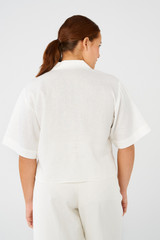 Profile view of model wearing the Oroton Lily Embroidered Shirt in White and 100% linen for Women