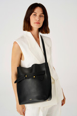 Profile view of model wearing the Oroton Post Hobo in Black and Pebble leather with smooth leather trims for Women