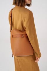 Profile view of model wearing the Oroton Post Hobo in Amber/Cognac and Pebble leather with smooth leather trims for 