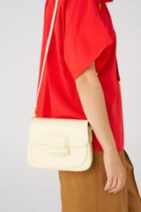 Profile view of model wearing the Oroton Carter Small Day Bag in Lemon Butter and Smooth leather for Women