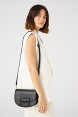 Profile view of model wearing the Oroton Dahlia Saddle Bag in Black and Smooth leather for Women