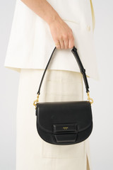 Profile view of model wearing the Oroton Dahlia Saddle Bag in Black and Smooth leather for Women