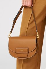 Profile view of model wearing the Oroton Dahlia Saddle Bag in Amber and Smooth leather for Women
