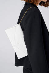Profile view of model wearing the Oroton Louisa Clutch in Pure White and Italian embossed leather for Women