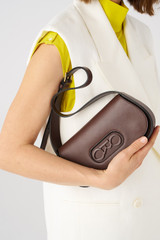 Profile view of model wearing the Oroton Oro Baguette in Bear Brown and Smooth leather for Women