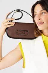 Profile view of model wearing the Oroton Oro Baguette in Bear Brown and Smooth leather for 