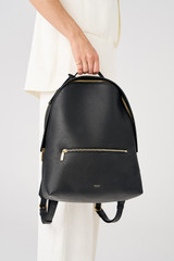 Profile view of model wearing the Oroton Margot Zip Backpack in Black and Pebble leather for Women