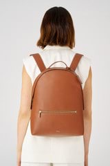 Profile view of model wearing the Oroton Margot Zip Backpack in Whiskey and Pebble leather for Women