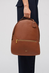 Profile view of model wearing the Oroton Margot Zip Backpack in Whiskey and Pebble leather for Women