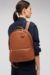 Profile view of model wearing the Oroton Margot Zip Backpack in Whiskey and Pebble leather for Women